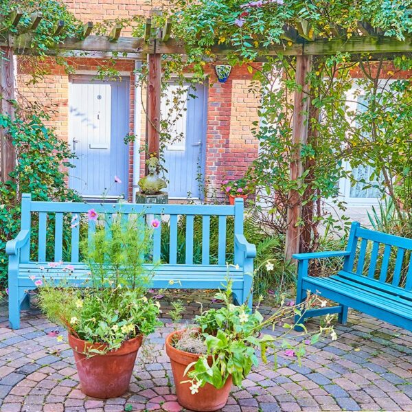 Image of two blue benches in one of HUC's almshouse gardens.
