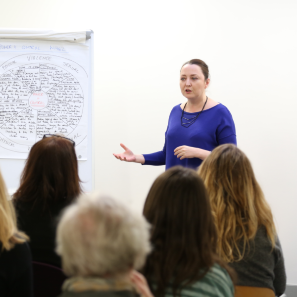 Woman giving talk on domestic abuse to other women