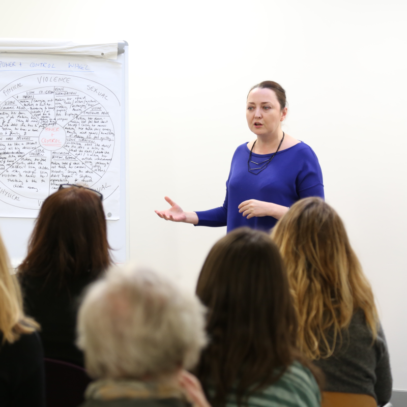 Woman giving talk on domestic abuse to other women