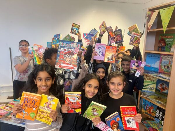 Lots of children smiling showing their gifted books