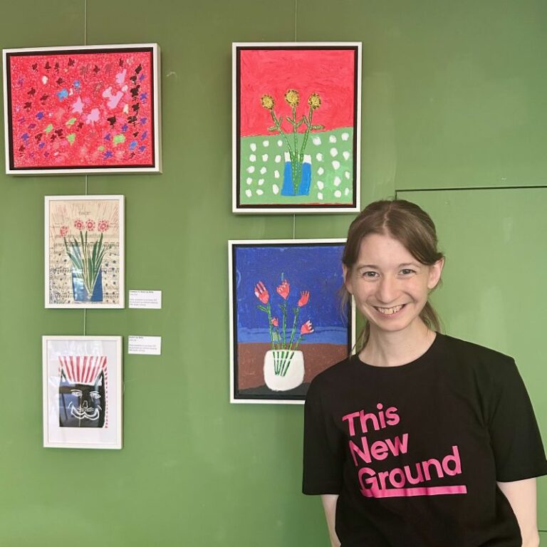 Kelly, one of the This New Ground artists, with some of her paintings