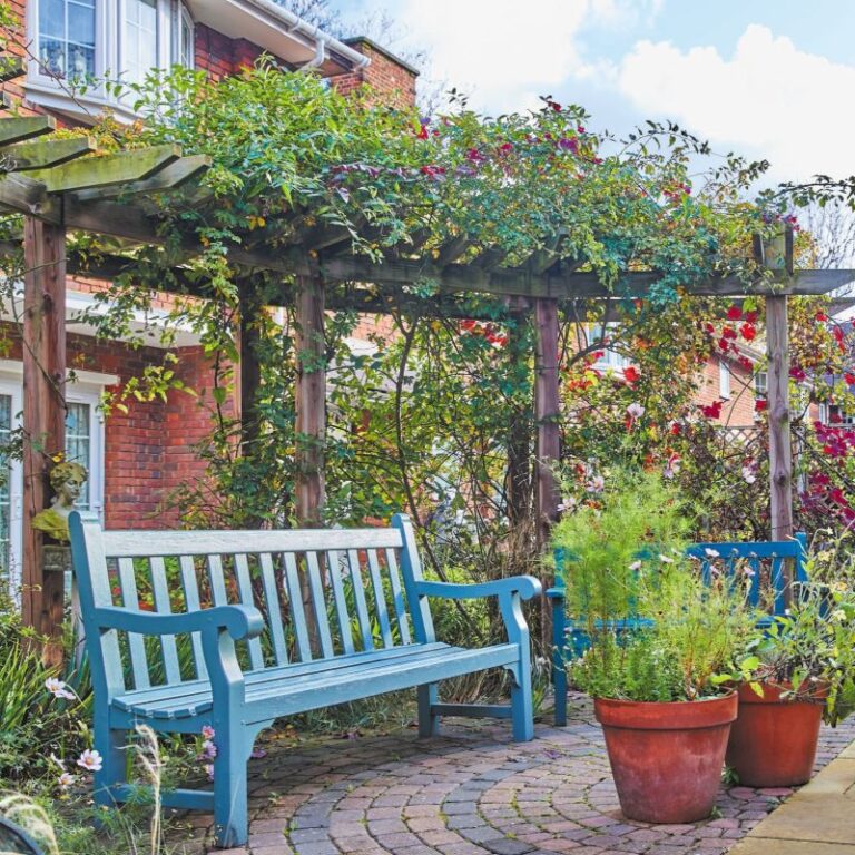 Image of garden with blue bench in the foreground