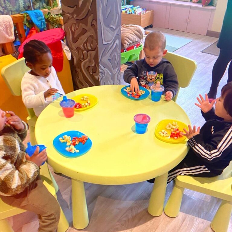 A group of young children (aged under 5) sitting around a table and playing.
