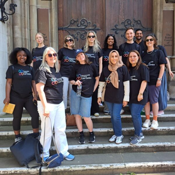 A group of women standing on the steps of the Royal Court of Justice. They are wearing t-shirts saying Hammersmith Law Society.