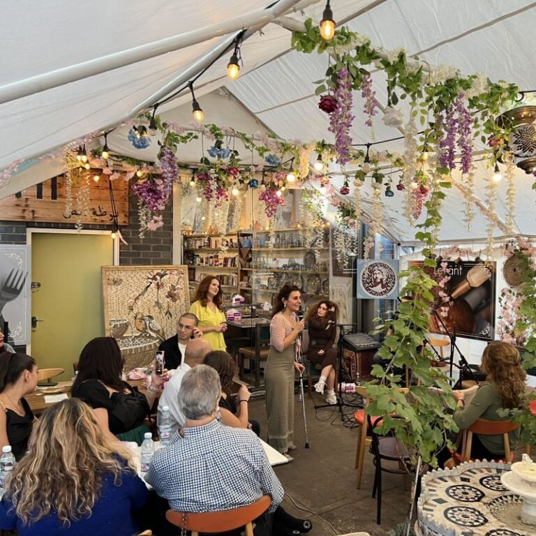 A woman is giving a talk to an audience. They are in a marquee.