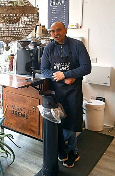 Gancho, a barista, standing in Petit Miracles shop