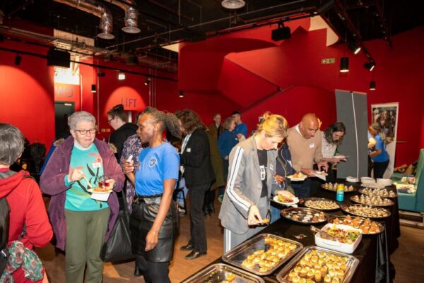 People gathering around the food table at the film screening