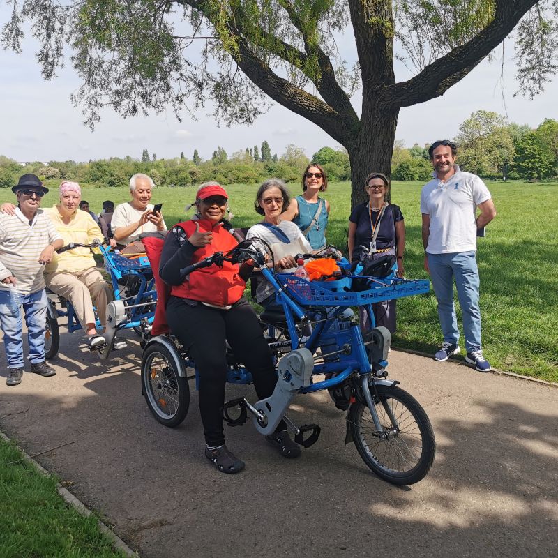 A group of people on or around a shared bicycle