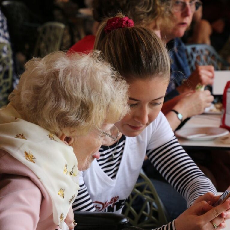 Two women: a younger volunteer and the older person she is supporting
