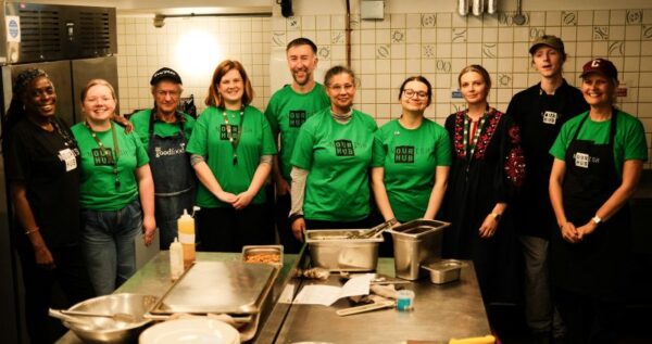 A group of Nourish Hub volunteers and staff members in the kitchen