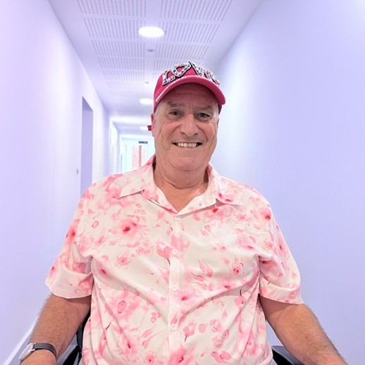One of our residents, Stuart, wearing a floral shirt and a pink cap embellished with the word Love.